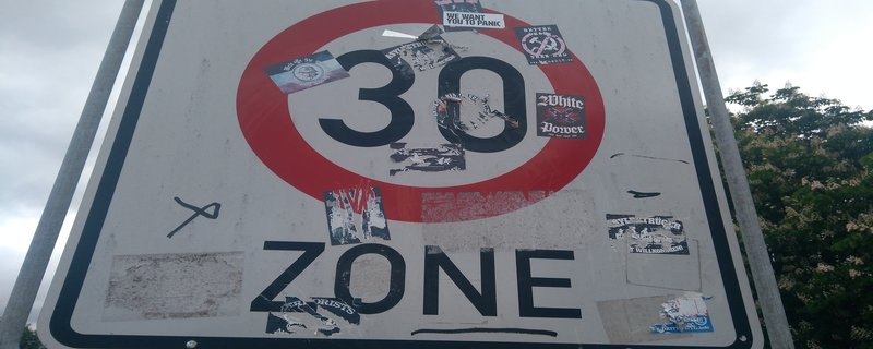 Foto zeigt Straßenschild mit extrem rechten Stickern