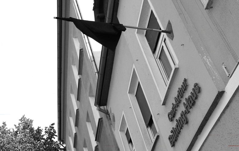 schwarz-weiß Foto des Carl-Arthur-Bühring-Haus, an dem eine schwarze Fahne hängt