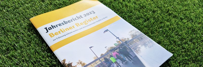 Die Titelseite des Jahresberichts für 2023 zeigt einen Fußgängerübergang zu einem Marzahner S-Bahnhof im Regen mit ca. fünf Personen, die von hinten zu sehen sind.